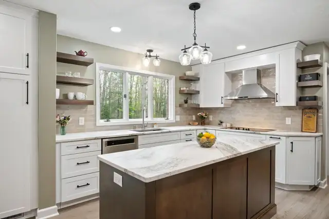 Blacksburg kitchen with white cabinets, floating wood shelves, a stained island with a marble-look top and a glass pendant