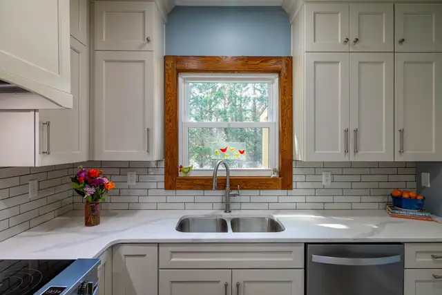 Kitchen remodel in a 1919 Sears kit house in Pembroke, VA with white shaker cabinets, subway tile and original stained window trim