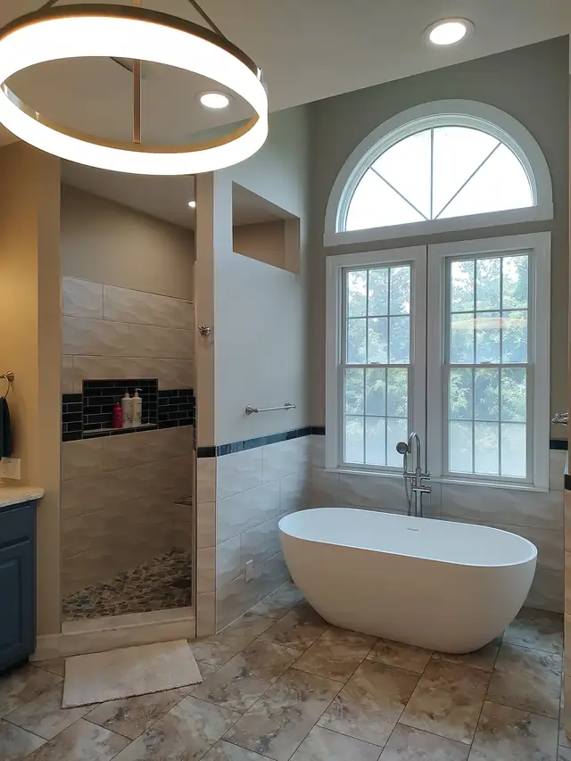 Primary bathroom with a freestanding tub under arched windows, a walk-in tile shower and a ring light fixture