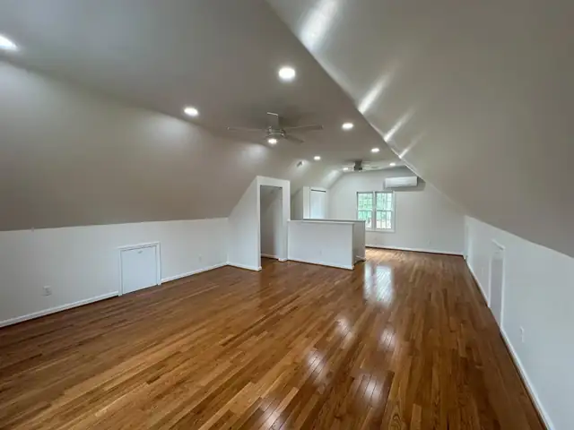 Finished attic over a garage in Christiansburg with sloped ceiling, recessed lights and hardwood floors